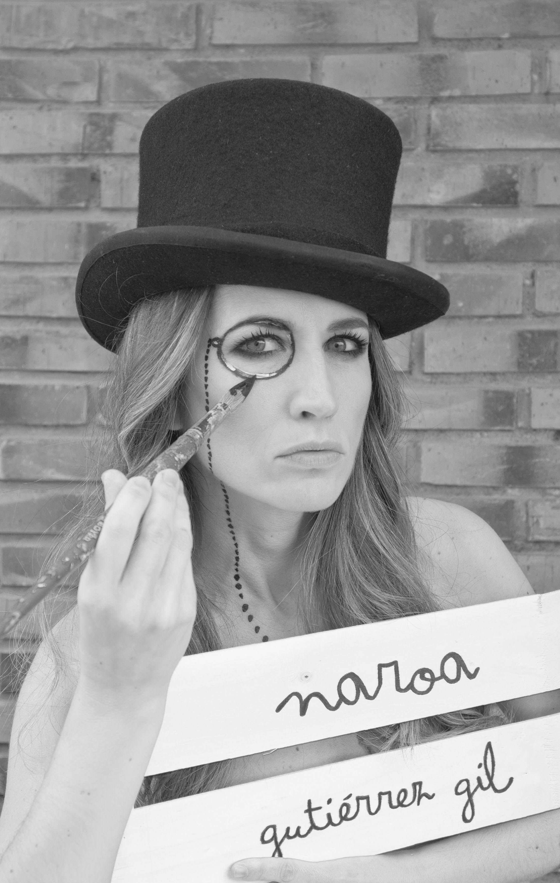 Naroa Gutiérrez Gil con chistera, sosteniendo un monóculo ante un ojo